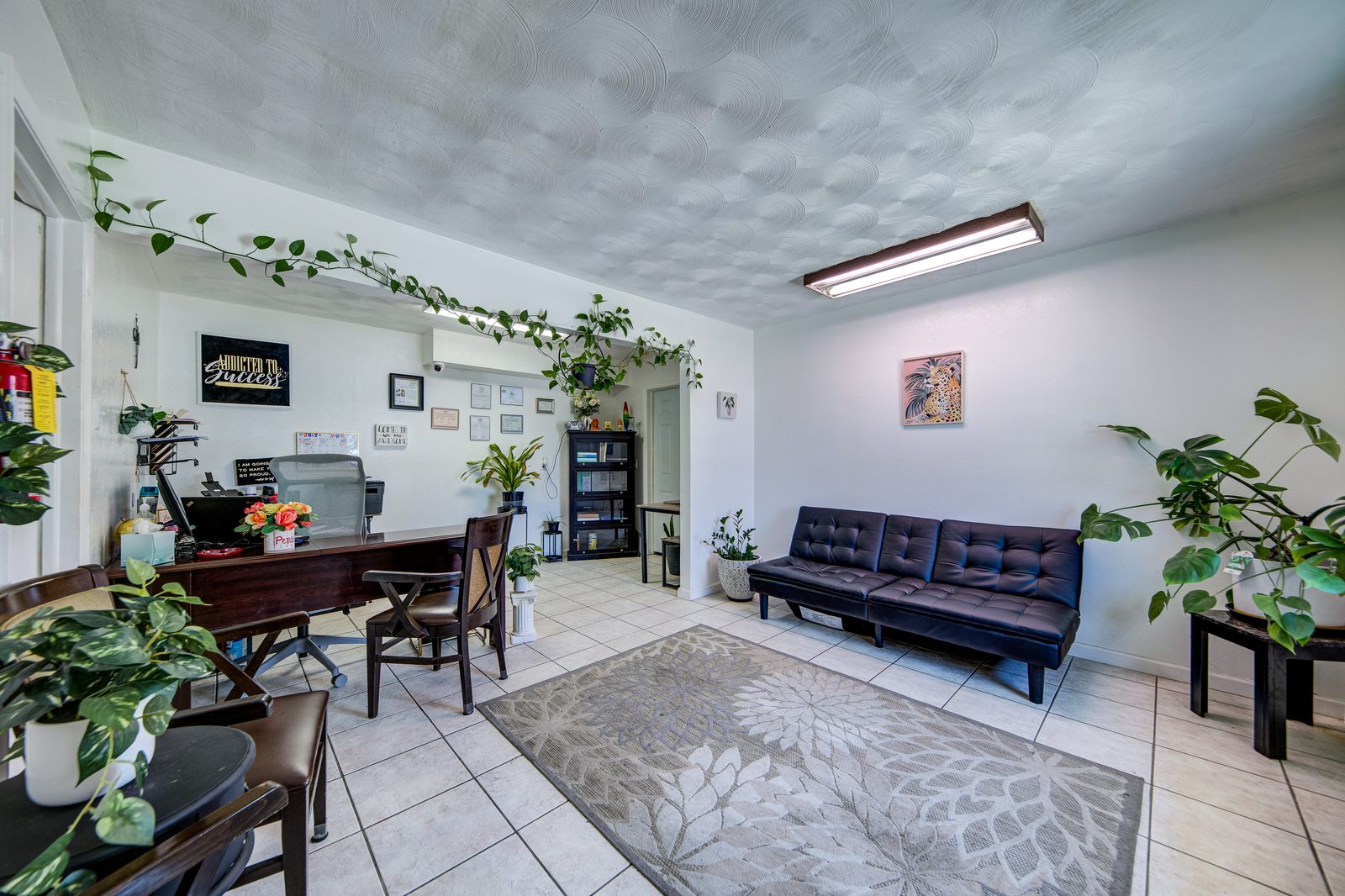 Leasing office at Oakwood Crest Apartments with plants, a desk and a sofa