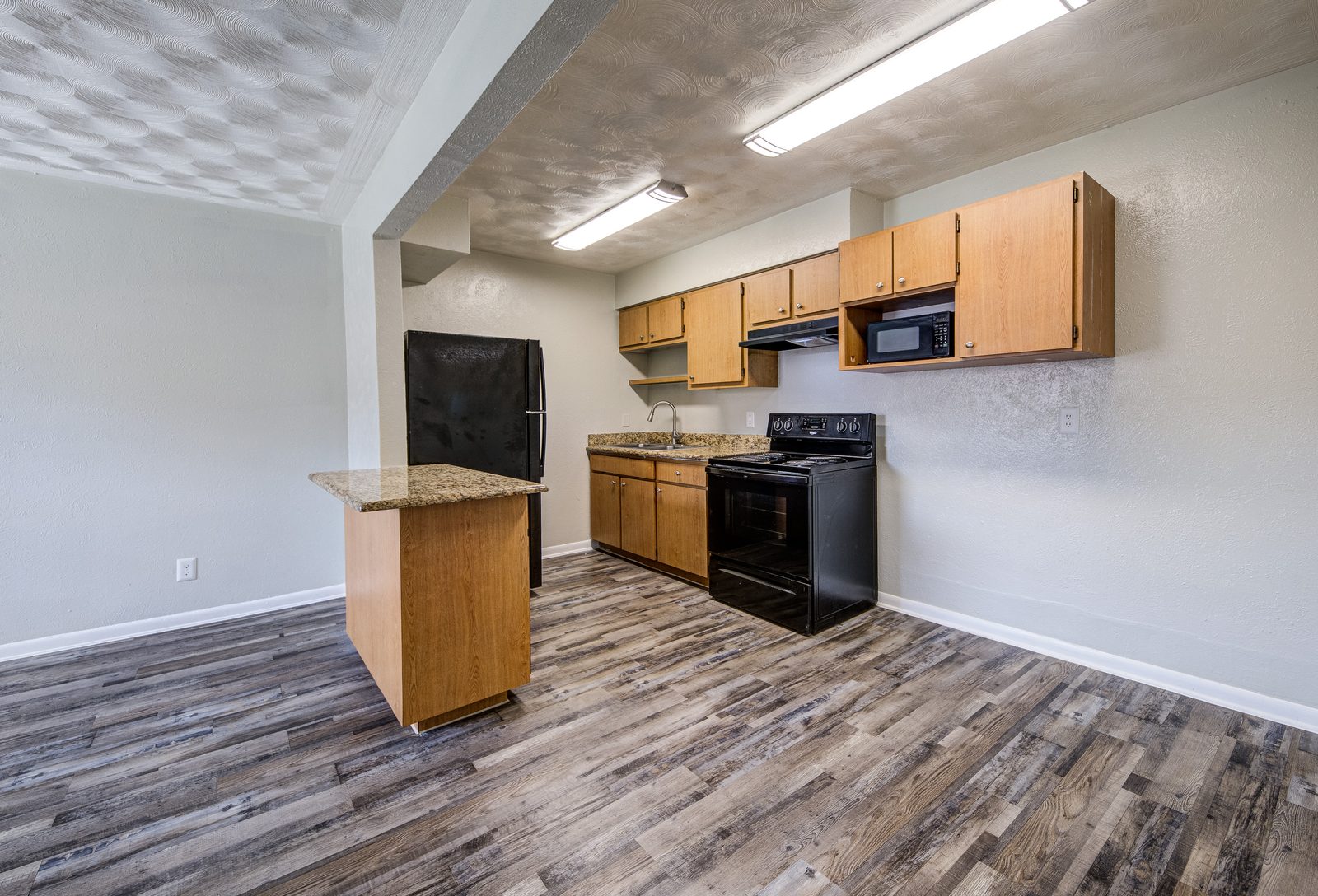 Kitchen and dining area with a kitchen island and black appliances