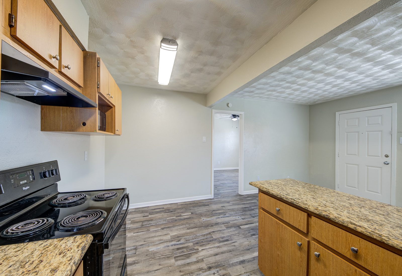 Kitchen with granite counters, looking toward the dining area and the front door