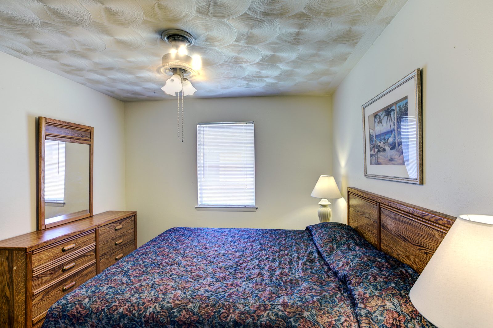 Furnished White Oak bedroom with a bed, a dresser and a ceiling fan